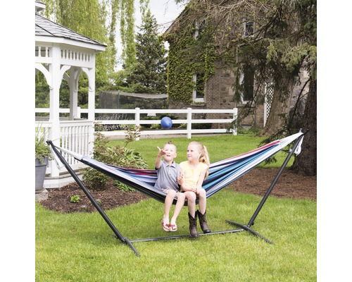 Kinder sitzen in einer gestreiften Hängematte mit Gestell im Garten.