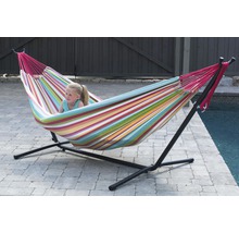 Fille se détend dans un hamac rayé avec un cadre en métal noir dans le jardin