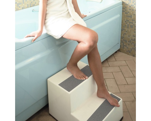 Frau mit Handtuch betritt Badewanne mit Treppe