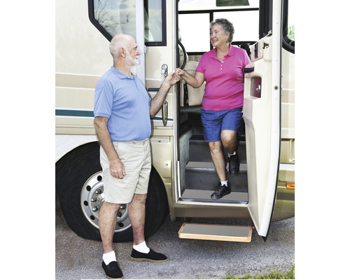 Ein Paar steigt aus einem Wohnmobil mit ausziehbarer Trittstufe.