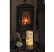 Lanterne décorative avec l''inscription Joyeux Noël, motifs de cerf et cheminée en arrière-plan.