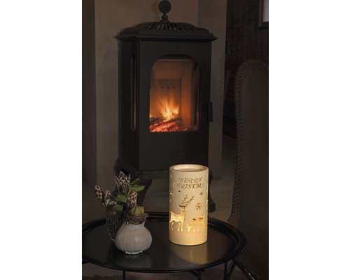 Lanterne décorative avec l''inscription Joyeux Noël, motifs de cerf et cheminée en arrière-plan.