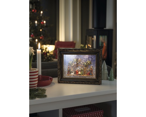 Dekorative Krippe im Bilderrahmen mit weihnachtlicher Szene auf einem Tisch