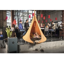 Scène d''intérieur avec une tente suspendue dans laquelle se trouve un enfant.