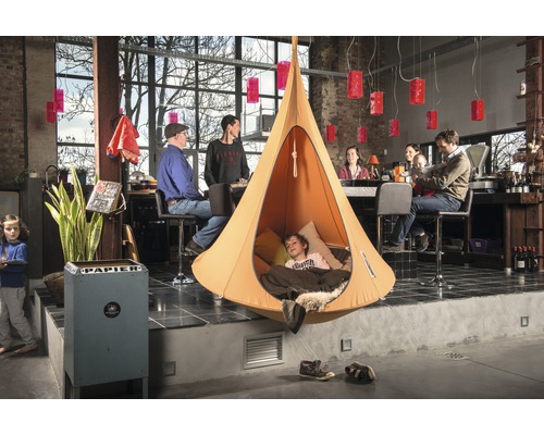 Scène d''intérieur avec une tente suspendue dans laquelle se trouve un enfant.