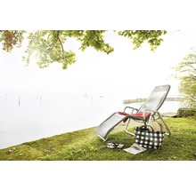 Scène avec chaise longue, sac de plage et lac en arrière-plan