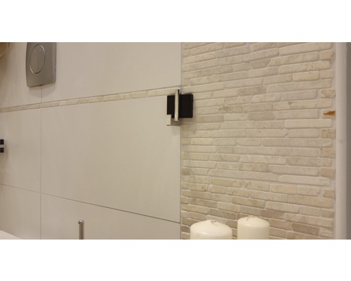 Detailansicht eines Badezimmers mit Fliesenwand und Sanitärobjekten