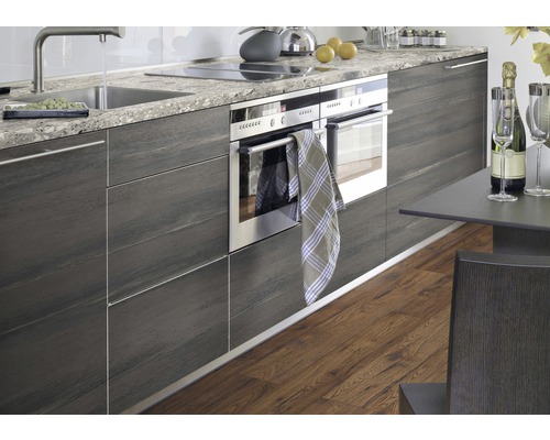 Cuisine moderne avec placards intégrés, évier, plaque de cuisson et four.