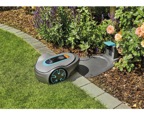 Robot tondeuse Gardena avec station de charge sur une pelouse dans le jardin