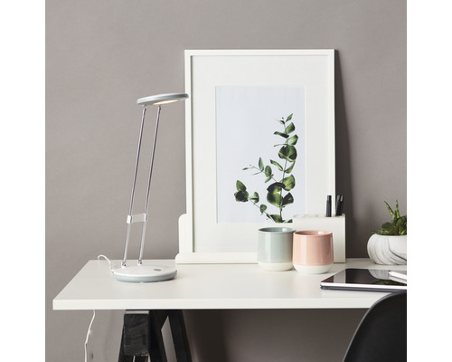 Schreibtisch mit Lampe, gerahmtem Bild, Stiften und Tassen