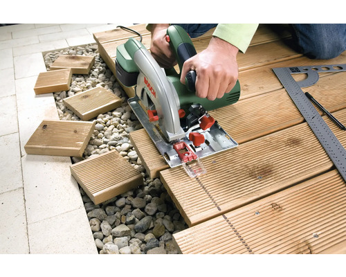 Un opérateur utilise une scie circulaire pour couper du bois pour une terrasse