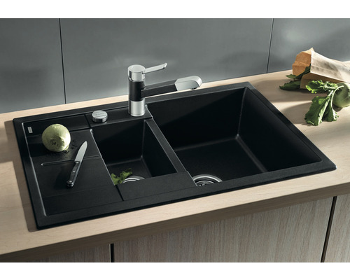 Schwarzes Spülbecken mit zwei Becken, Armatur und Abtropffläche auf einer Arbeitsplatte