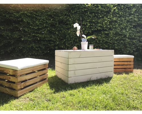 Gartenszene mit Holztisch und Hockern mit Kissen