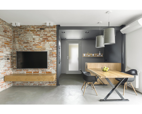 Salon moderne avec mur en briques, télévision, table en bois et chaises