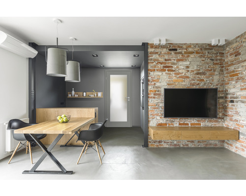 Modernes Wohnzimmer mit Esstisch, Stühlen, Fernseher und Backsteinmauer