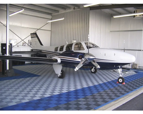 Avion dans un hangar avec des carreaux de sol.