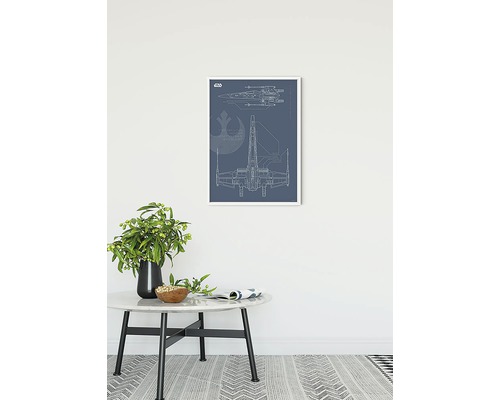 Gerahmter Bauplan eines Raumschiffs an der Wand über einem Beistelltisch.