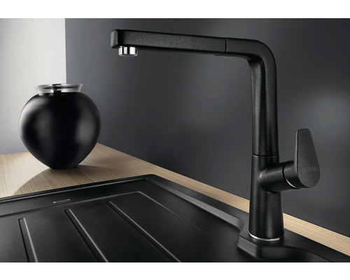 Robinet de cuisine noir avec douchette extractible à côté de l''évier et de la décoration