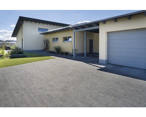 Aussenaufnahme eines Hauses mit gepflasterter Einfahrt, Garage und Carport