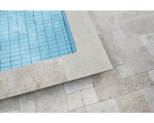 Vue détaillée d''une piscine avec bordure et carrelage en travertin