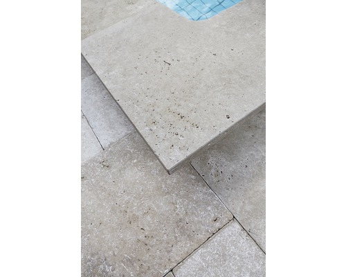 Gros plan de dalles en travertin autour d''une piscine