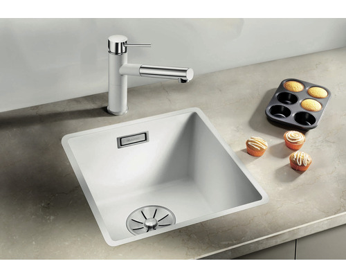 Évier avec mitigeur et muffins sur un comptoir de cuisine