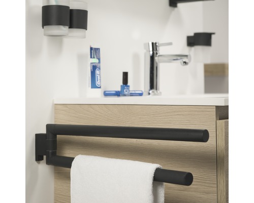 Salle de bains avec lavabo, robinet, gobelet à brosse à dents, serviette et porte-serviettes pivotant