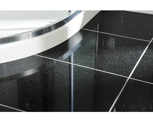 Gros plan sur les carreaux et le receveur de douche dans la salle de bain.