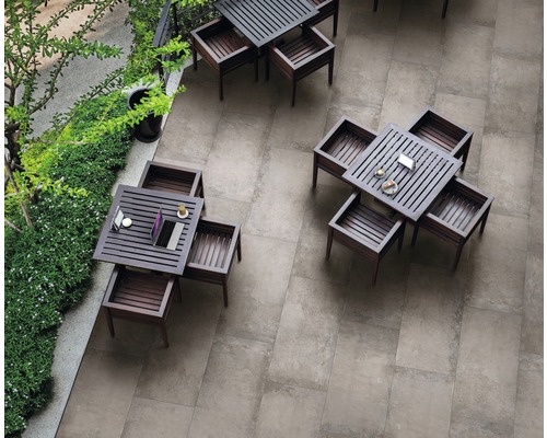 Vue de dessus d''un espace extérieur avec des carreaux de sol gris et plusieurs tables carrées en bois avec des chaises assorties
