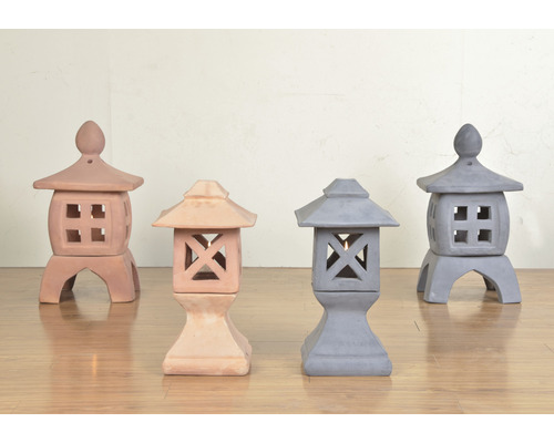 Vier Gartenlaternen aus Terrakotta und Beton auf einem Holzboden