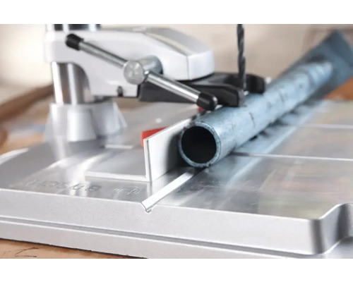 Un tuyau métallique est percé à l''aide d''une perceuse à colonne