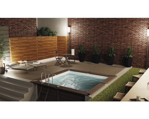 Espace extérieur avec piscine, chaises longues, table et chaises sur une terrasse en bois devant un mur de briques