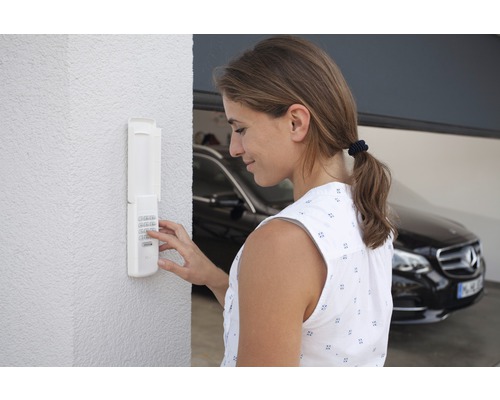 Femme actionnant une porte de garage avec un code numérique