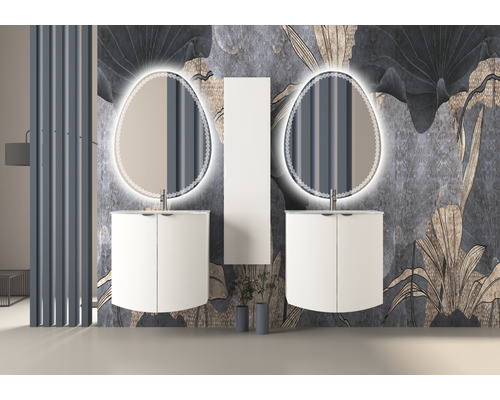 Salle de bains avec deux meubles sous-lavabo, des miroirs éclairés et une armoire haute devant un papier peint floral.