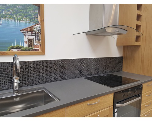 Küchenszene mit Spüle, Armatur, Mosaikfliesen, Kochfeld, Backofen und Dunstabzugshaube.
