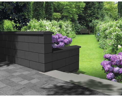 Aménagement paysager de jardin avec un mur en parpaings de béton et des parterres de fleurs