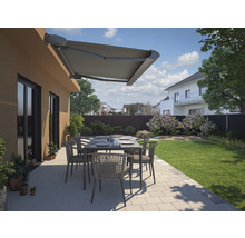Terrasse avec store, table et chaises dans un jardin