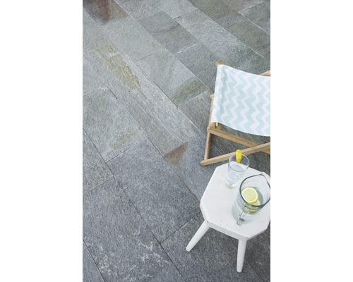 Espace extérieur avec dalles en pierre naturelle, chaise longue et table d''appoint avec boissons