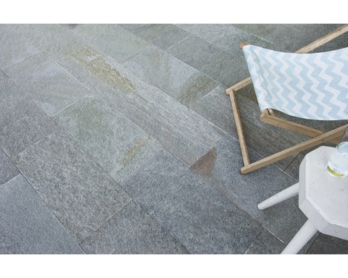 Sol en pierre naturelle posé avec chaise longue et table d''appoint