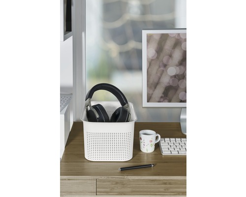 Scène de bureau avec panier de rangement, casque, tasse et stylo