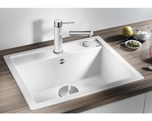 Weisses Spülbecken mit Armatur und Ablaufgarnitur auf einer Arbeitsplatte