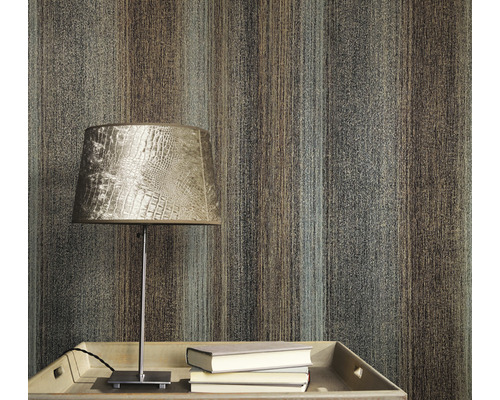 Nahaufnahme einer Wand mit einer Tapete mit Streifenmuster, einem Tisch mit einer Lampe und Büchern