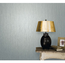 Gros plan d''un mur avec du papier peint texturé à côté d''une table avec une lampe