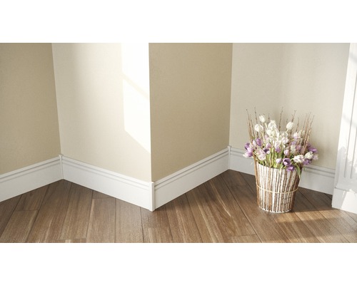 Coin de pièce avec plinthes blanches et plancher en bois