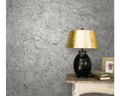 Wohnraum mit Tapete in Rissoptik, Lampe und Tisch