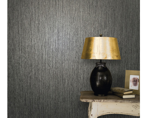 Gros plan d''un mur avec du papier peint texturé, une table et une lampe de table.