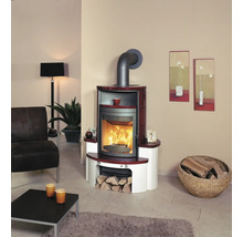 Wohnzimmer mit Kaminofen, Sessel und Holzkorb