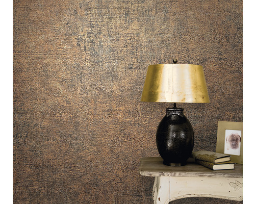 Gros plan d''un mur avec un papier peint texturé à côté d''une table avec une lampe, des livres et un cadre photo.