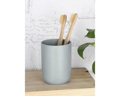 Deux brosses à dents en bambou dans un gobelet clair