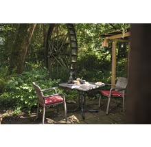 Scène de jardin avec table, chaises et moulin à eau en arrière-plan